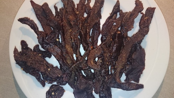 Pictures shows a plate full with a bunch of smoked teriyaki flavored beef jerky